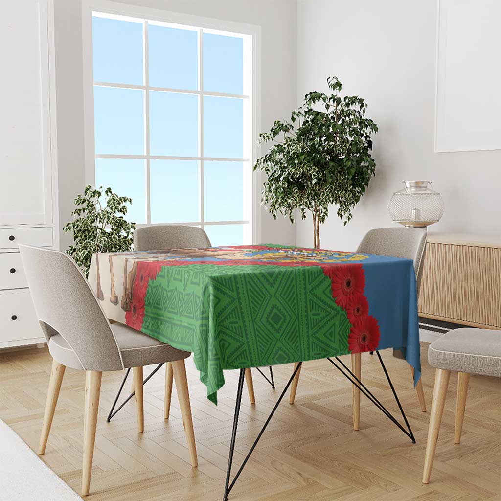 Green tablecloth over dining table with camel and floral Eritrea flag artwork