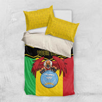 Mali bedding set with two yellow patterned pillows and multicolor duvet featuring coat of arms