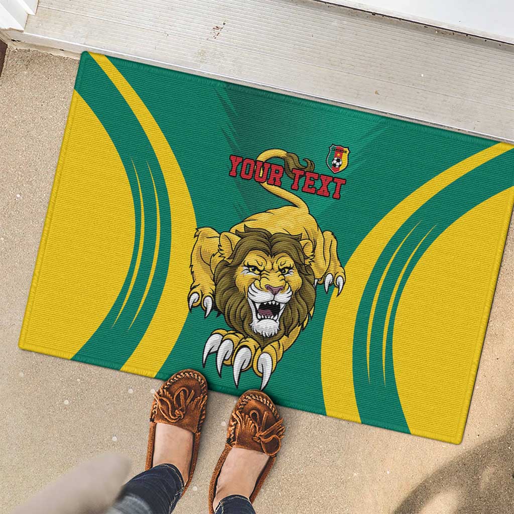Green rubber doormat with lion face and curved yellow stripes, 'YOUR TEXT' shown
