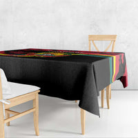 Mozambique Revolution Day tablecloth on bench, black fabric with multicolor striped edge.