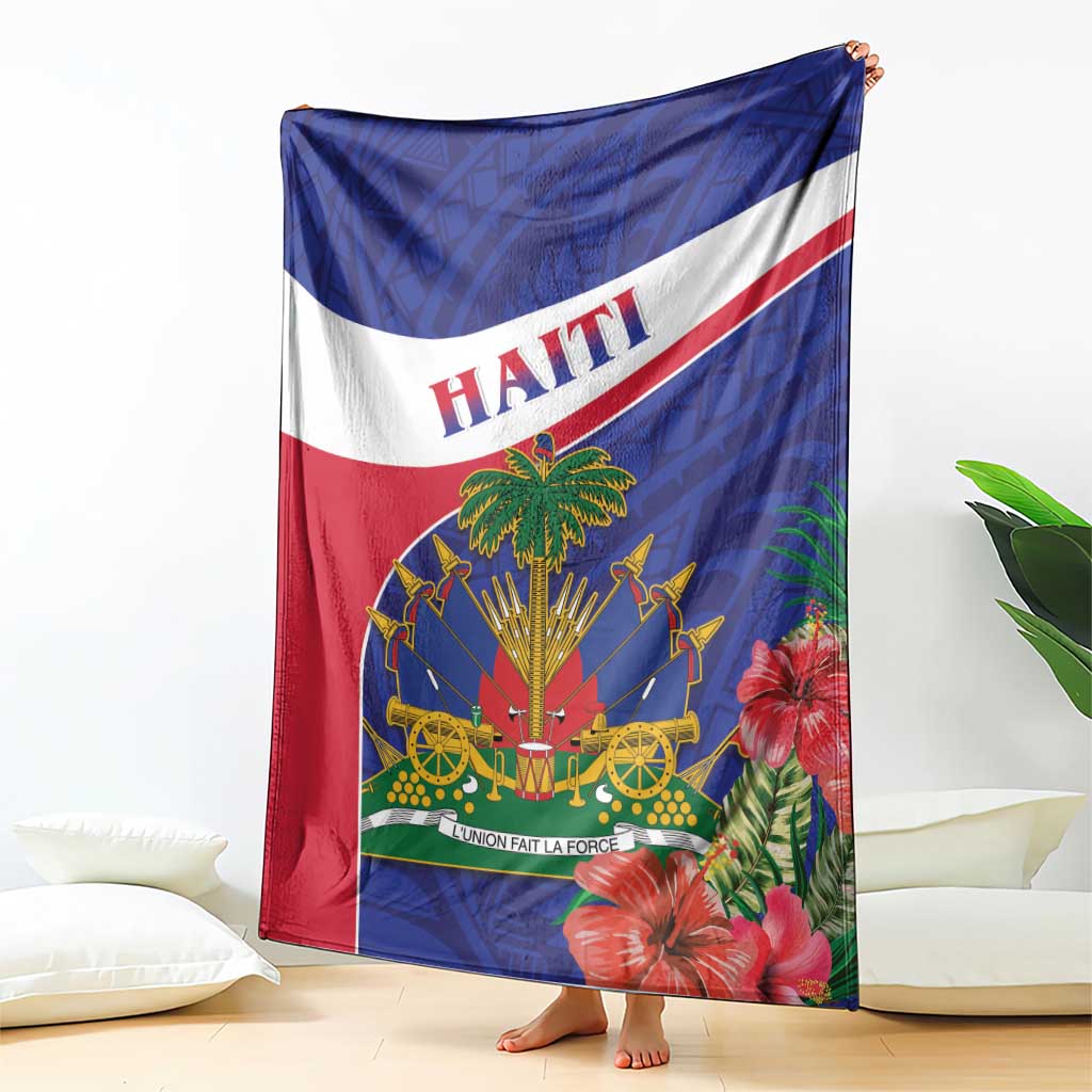 Haiti blanket draped on a bed, blue and red with palm and flower emblem