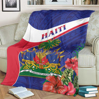 Haiti blanket on couch, blue-and-red design with Haiti lettering and palm centerpiece