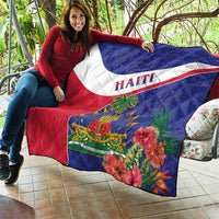Haiti quilt draped over couch cushions in blue, white, and red with hibiscus flower print