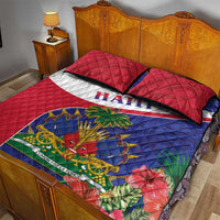 Quilt bed set with red and blue quilt featuring “HAITI” stripe, emblem center, and floral accents