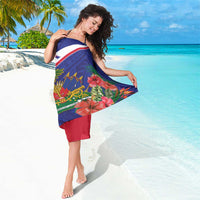 Blue and red sarong with white diagonal stripe, hibiscus and palms, worn as beach wrap