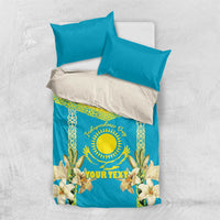 Blue bedding set with white pillows and yellow sun emblem design, lily floral accents