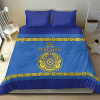 Blue bed set with two pillows; yellow ornamental band and central crest design