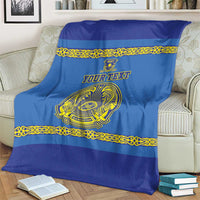 Blue custom hockey blanket on a couch with gold trim and central crest emblem, custom text