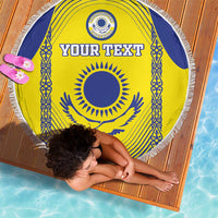 Round beach blanket with yellow center, blue flag border motifs, tassel fringe, “YOUR TEXT”.