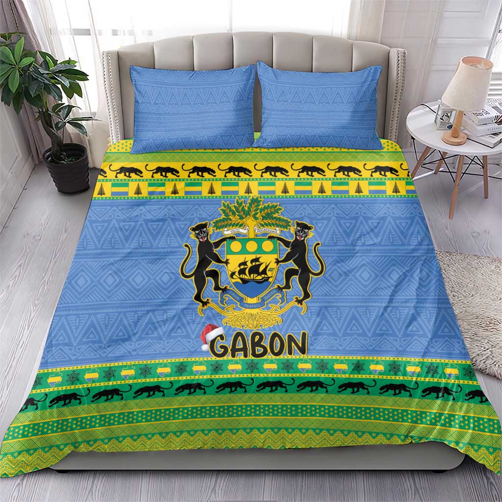Blue bedding set on bed with two pillows; Gabon coat of arms, green-and-yellow stripe trim