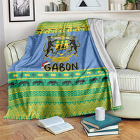 Blue Christmas blanket with coat of arms crest, green/yellow stripes, and animal border