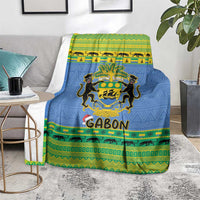 Blue Christmas blanket over sofa with coat of arms crest and 'GABON' lettering at center