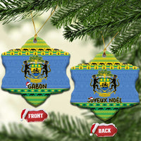 Two blue heart-shaped Gabon ceramic ornaments on tree with coat of arms designs