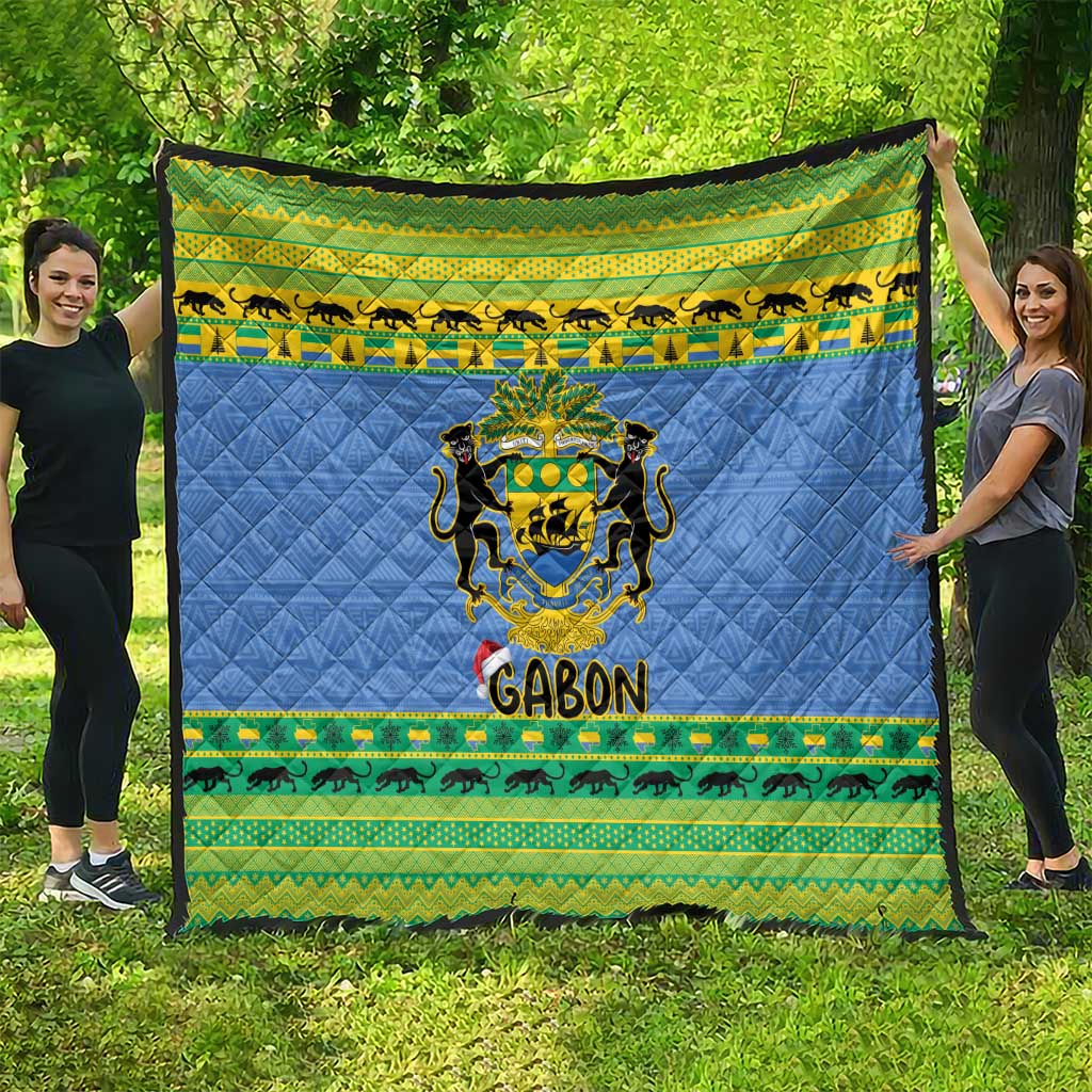 Blue quilt blanket draped outdoors with Gabon coat of arms and green animal stripe border.