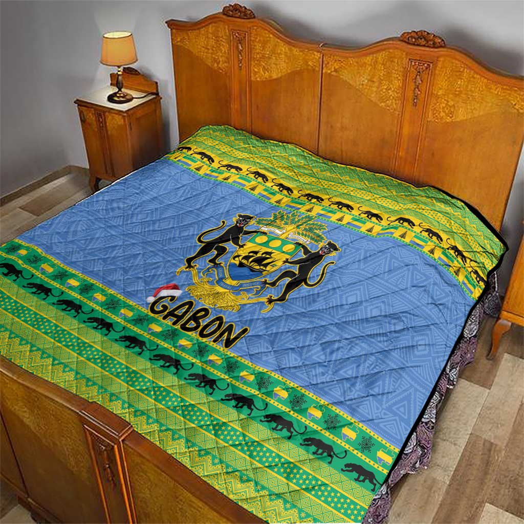 Blue bed quilt with Gabon coat of arms and green animal stripe border across top.