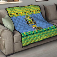 Blue quilt blanket on sofa with Gabon coat of arms and green animal stripe trim edges.