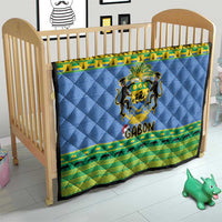 Blue quilt blanket on baby crib with Gabon coat of arms and green animal stripe border.