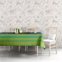 Blue and green holiday tablecloth with Gabon crest on long dining table with chairs
