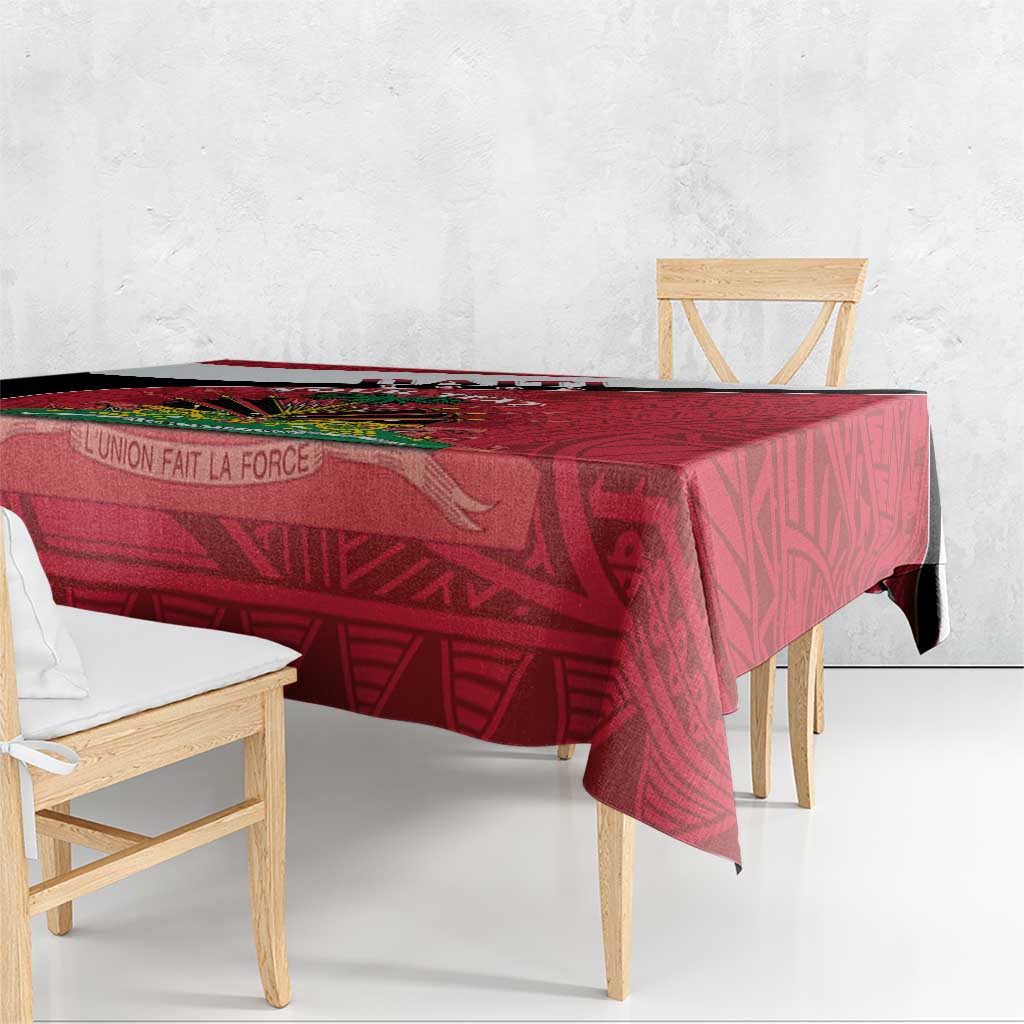 Red Haiti tablecloth with geometric design and emblem banner across the top edge