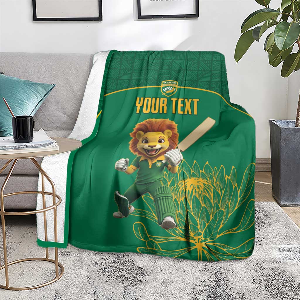 Green cricket blanket on floor with lion mascot and 'YOUR TEXT' center artwork