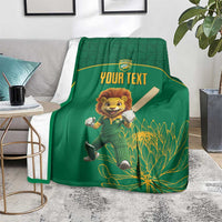Green cricket blanket on floor with lion mascot and 'YOUR TEXT' center artwork