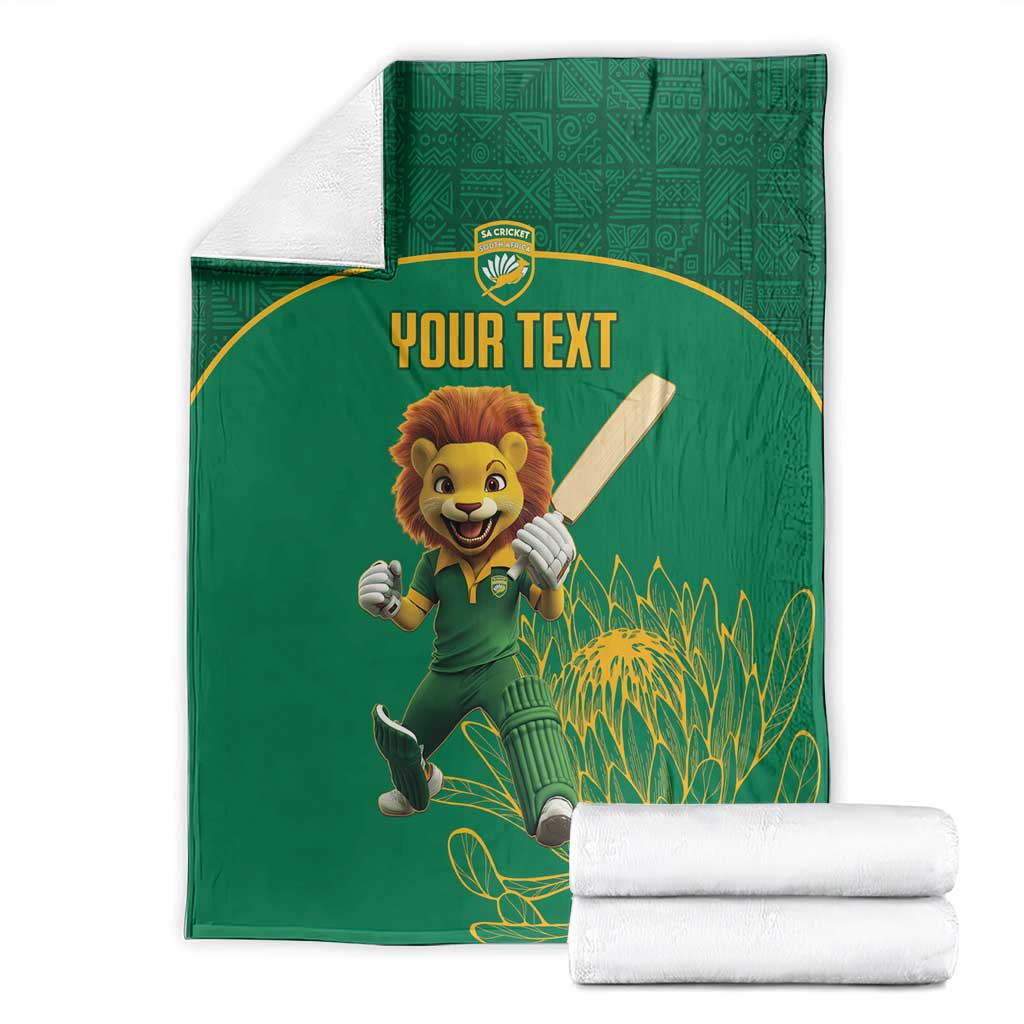 Green cricket blanket folded with lion mascot and 'YOUR TEXT' front, botanical background
