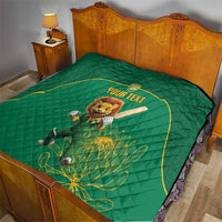 Green quilt blanket on a bed, featuring lion mascot in yellow-bordered custom text circle