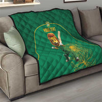 Green quilt blanket draped over a sofa, featuring lion mascot and yellow-bordered custom text circle