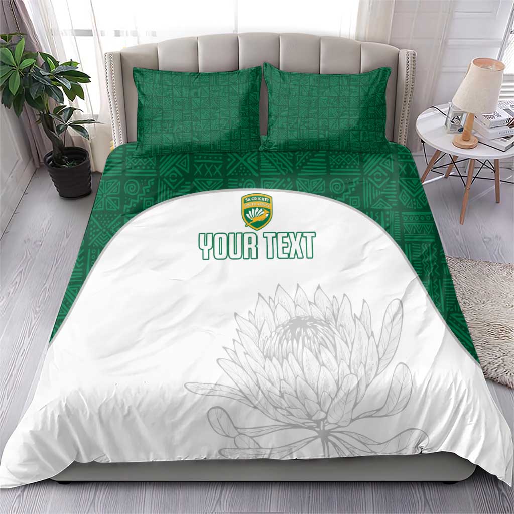 Green and white bedding set on bed: white duvet with floral sketch and custom text