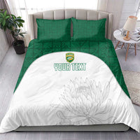 Green and white bedding set on bed: white duvet with floral sketch and custom text