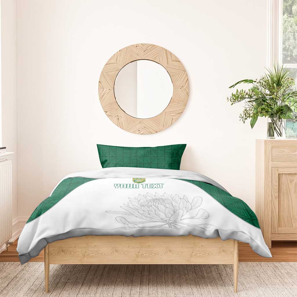 White duvet with floral line art and custom text, green pillows, bedding set on wooden bed