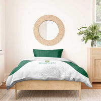 White duvet with floral line art and custom text, green pillows, bedding set on wooden bed