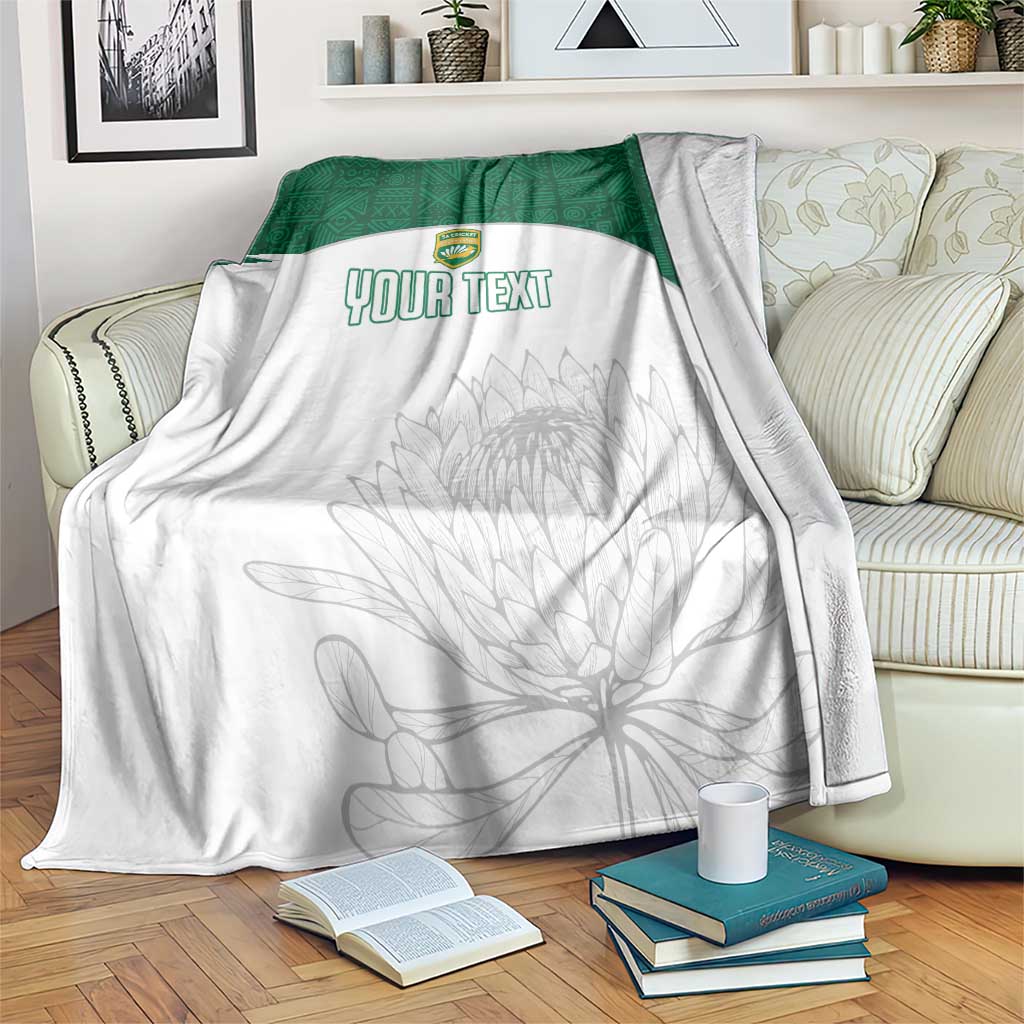 Custom cricket blanket with white base, green border, crest, and gray protea outline; YOUR TEXT