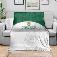 White and green custom cricket blanket draped on sofa; crest logo, gray protea print, YOUR TEXT