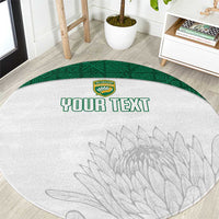 Round white cricket-themed rug with green border, crest, gray leaf graphic, 'YOUR TEXT'.