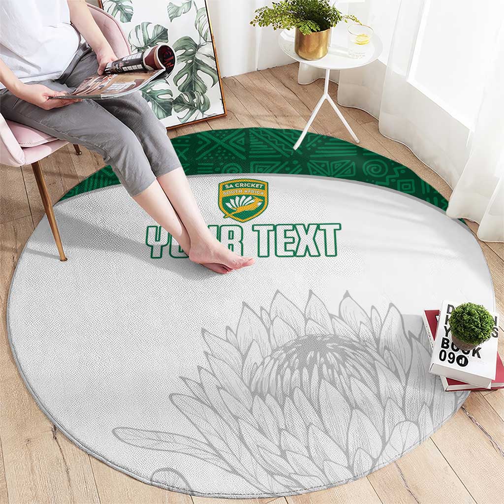 Round white cricket-themed rug with green ring border, crest logo, gray leaf design, 'YOUR TEXT'.