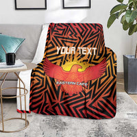 Cricket blanket folded on chair, Eastern Cape eagle print in orange, red, and black geometric design