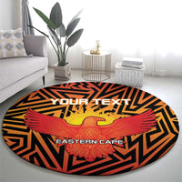 Round orange rug with black zigzags and red-and-yellow eagle design with centered text