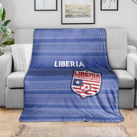 Blue striped football blanket with LIBERIA text and team crest, on gray couch