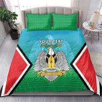 Personalised bedding set on a bed with teal duvet, green pillowcases, bold coat-of-arms center
