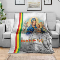 Christmas blanket draped on sofa, Saint Mary illustration with rainbow stripe and church tower