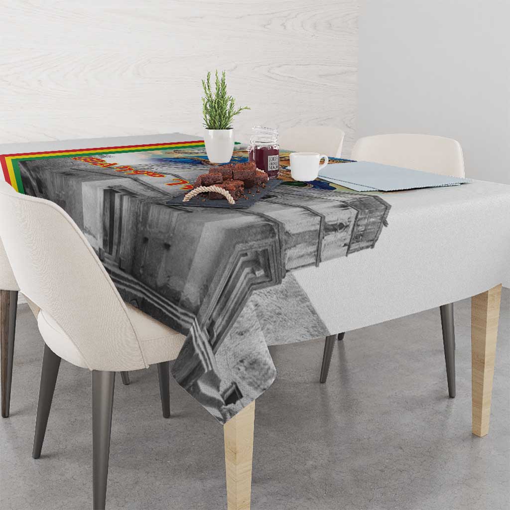 Corner view of Christmas tablecloth with gray church illustration and multicolor edge stripe