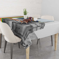 Corner view of Christmas tablecloth with gray church illustration and multicolor edge stripe