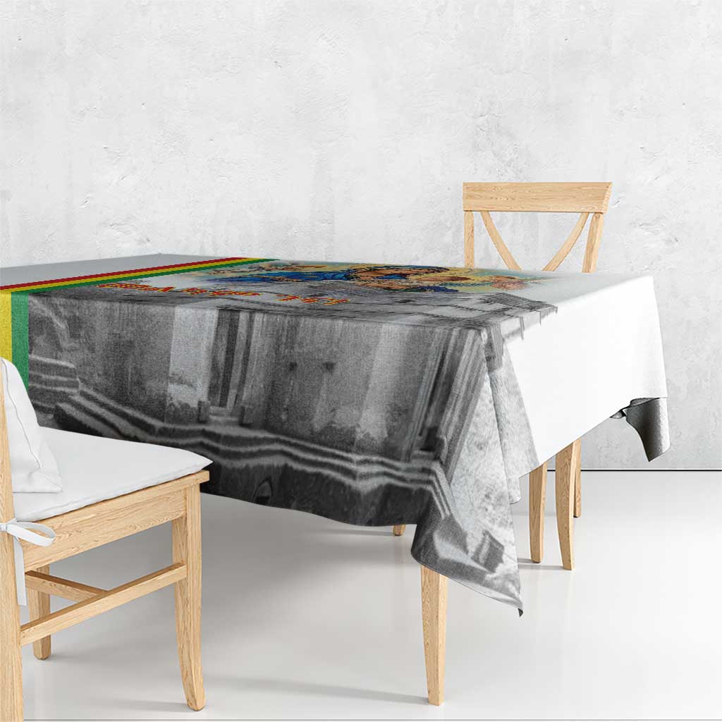 Christmas tablecloth with gray church artwork and multicolor stripe border on tabletop