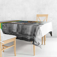 Christmas tablecloth with gray church artwork and multicolor stripe border on tabletop