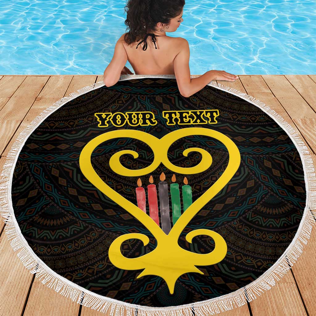 Round black beach blanket with white fringe, yellow heart and Adinkra pattern, 'Your Text' in use