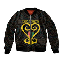 Black bomber jacket with yellow heart emblem, zip front, and Adinkra-style pattern