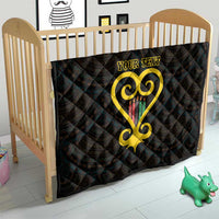 Black quilt for a crib with yellow Adinkra heart and 'YOUR TEXT' centered.