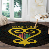 Black round rug with yellow Sankofa heart and Adinkra pattern; multicolor candle details
