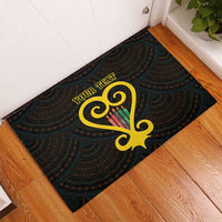 Black rubber doormat with teal ornate pattern and gold Sankofa heart with custom text